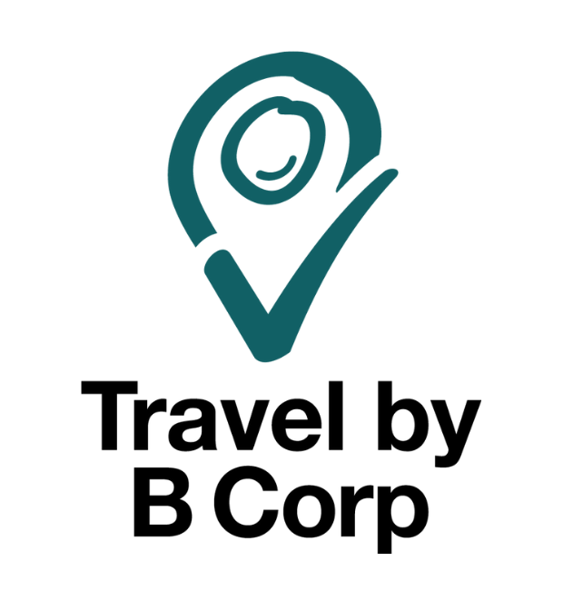 A teal location pin with a check mark encloses a smiling face, above bold black text reading "Travel by B Corp" on a white background.
